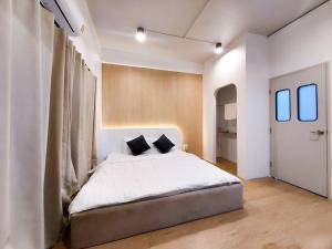 a bedroom with a large white bed with two pillows at Matcha House jomtien Pattaya in Jomtien Beach