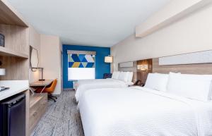 a hotel room with two beds and a desk at Holiday Inn Express & Suites Ormond Beach - North Daytona by IHG in Ormond Beach +34 photos