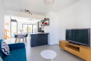 a living room with a blue couch and a tv at Duplex Terrasse Parking - Paris Montreuil in Montreuil