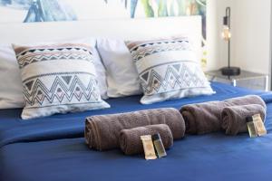 a blue bed with towels and pillows on it at Duplex Terrasse Parking - Paris Montreuil in Montreuil