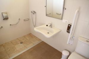 un bagno bianco con lavandino e WC di el albergue de herrera a Herrera de Pisuerga Altre 2 foto