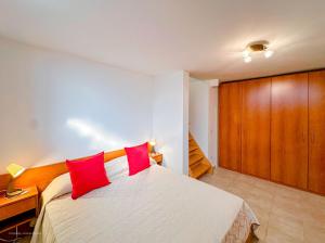 una camera con un letto con due cuscini rossi di Brunacci BEleven Suite - 5 min dai Navigli a Milano