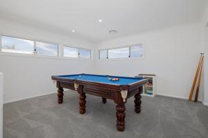 a pool table in a room with windows at Shoreline Luxe - Refined Beachside Elegance with Spa in Caves Beach