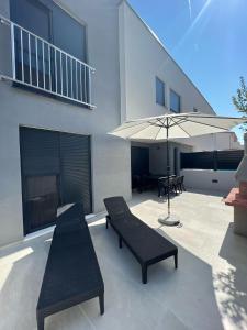 - une terrasse avec 2 bancs et un parasol dans l'établissement Residence Doli Superior, à Vrsi