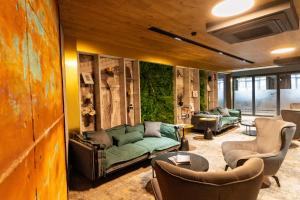 a living room with a green couch and chairs at MM Boutique Hotel in Burgas