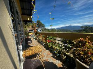 a balcony with chairs and potted plants on a building at VidHuset Homestay Sagada in Sagada