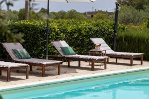 a group of chairs sitting next to a swimming pool at La casa dei Limoni con piscina Noto in Noto