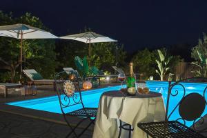 a table with a bottle of wine on it next to a pool at La casa dei Limoni con piscina Noto in Noto