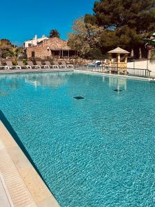 a large pool of blue water with a gazebo at Traumhafte Lodge mit einzigartigen Meerblick in Saint-Raphaël
