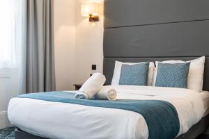 a bedroom with a large bed with blue and white pillows at The J Hyde Park Hotel in London