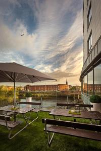 due tavoli da picnic e un ombrello accanto a un edificio di Absolute Hotel Limerick a Limerick