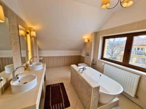a large bathroom with two sinks and a tub at Villa Velora - luxury & wellness in Odorheiu Secuiesc