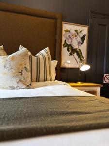 a bedroom with a bed with pillows and a painting at Osborne Manor Luxury Guesthouse in Kimberley +34 photos