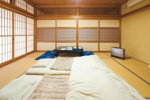 a room with four beds and a tv at 魚沼ヒミツ基地 in Uonuma