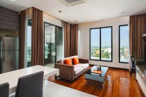 a living room with a couch and a table at Lumen Bangkok Srinakarin in Bangkok
