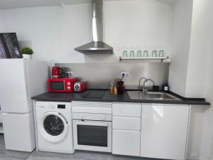 a kitchen with a sink and a washing machine at Santurce A2 Centro Wizink Bernabeu in Madrid