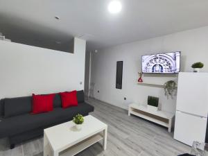 a living room with a black couch and red pillows at Santurce A2 Centro Wizink Bernabeu in Madrid