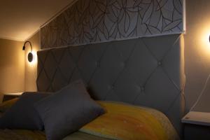 a bed with a large headboard and two pillows at Casa vacanze Etna in Santa Maria di Licodia +21 photos