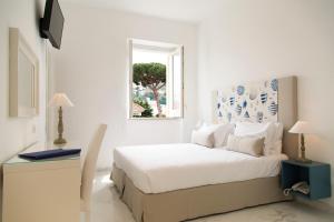 a white bedroom with a bed and a window at Hotel Crawford in Sant'Agnello