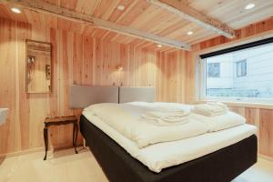 a bedroom with a large bed in a wooden wall at Central Tórshavn Stay in the Charming Old Town in Tórshavn