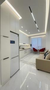 シムケントにあるЖК КАПИТАЛ СИТИ Евротрешкаのソファとテーブルのある白いリビングルーム