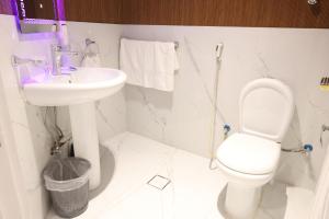 a white bathroom with a toilet and a sink at Orchid Private Tourism Accommodation Facility اوركيد - لمرافق الضيافة السياحية الخاصة in Medina +51 photos