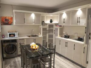 a kitchen with white cabinets and a table with fruit on it at Orchid Private Tourism Accommodation Facility اوركيد - لمرافق الضيافة السياحية الخاصة in Medina