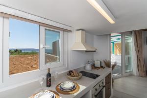 a kitchen with a counter with a sink and a window at Irida Luxury Residence in Adamantas