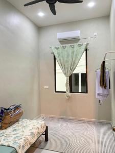 a bedroom with a bed and a window at Adeeb Homestay in Arau