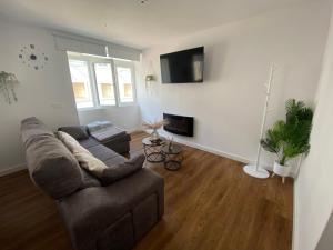 a living room with a couch and a tv at Apartamento El Baluarte in Cudillero