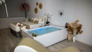 a bathtub in a room with a bed and a tub at El Rincón Secreto in Alcalá del Júcar