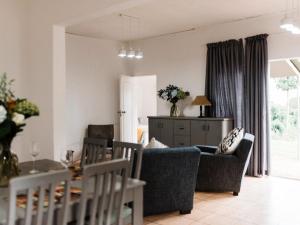 a living room with a couch and a table at Verkijken Cottage in Haenertsburg