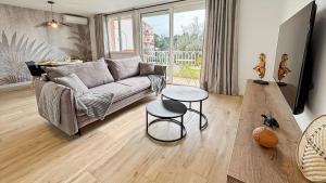 a living room with a couch and a table at Appartement a quelques minutes à pieds des plages in Fréjus