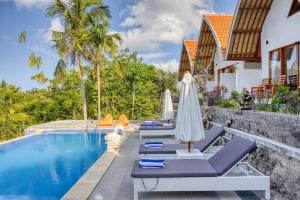 a row of chairs and umbrellas next to a swimming pool at Kelingking Beach Villas in Nusa Penida
