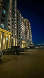 シムケントにあるЖК КАПИТАЛ СИТИ Евротрешкаの大きな建物の前に停車する車