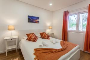 a bedroom with a white bed with two pillows and a window at Ocean, Pines and Mountain - Renovated February 2025 - AC in Sintra