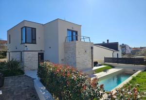 a house with a swimming pool in front of it at Villa Green s bazenom in Medulin