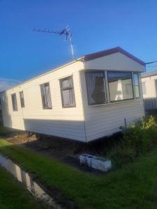 a mobile home is parked in a yard at Caravan 88 2 Bed Sleeps 6 Parking in Skegness +21 photos