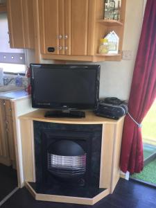 a tv on top of a fireplace in a caravan at Caravan 88 2 Bed Sleeps 6 Parking in Skegness