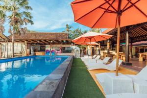 a swimming pool with umbrellas and chairs and a pool at Semayaone Beach Hotel in Nusa Penida