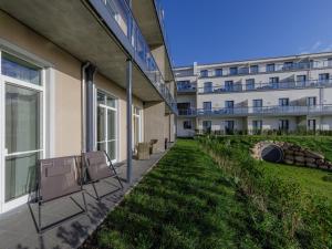 eine Reihe von Stühlen an der Seite eines Gebäudes in der Unterkunft ALTE SEEFAHRTSCHULE - ZWEI WASSER App 11 "Mohnblume" in Wustrow