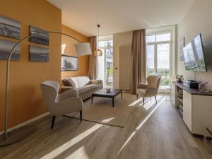 ein Wohnzimmer mit Couch und Stühlen in der Unterkunft ALTE SEEFAHRTSCHULE - ZWEI WASSER App 11 "Mohnblume" in Wustrow