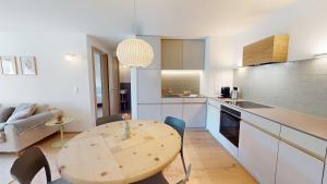 a kitchen with a wooden table in a room at Leonard in Celerina +5 photos