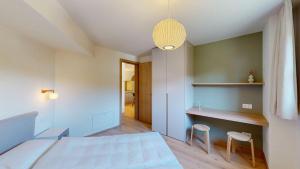 a bedroom with a bed and a desk with two chairs at Leonard in Celerina