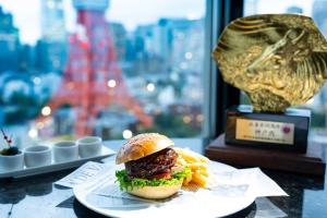 a hamburger and french fries on a plate with a trophy at The Prince Park Tower Tokyo - Preferred Hotels & Resorts, LVX Collection in Tokyo