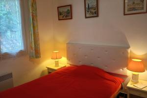 a bedroom with a red bed with two lamps at Apartment with terraces in Rayol-Canadel-sur-Mer in Rayol-Canadel-sur-Mer