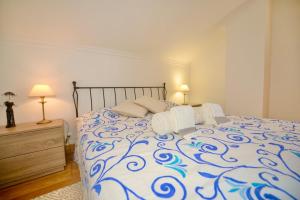 a bedroom with a blue and white bed with two lamps at 'Collasão' - Stunning Duplex with Pool & Sea Views in São Martinho do Porto +48 photos