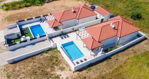 an overhead view of a house with a swimming pool at Villas Sabun - modern house with heated pool in Privlaka