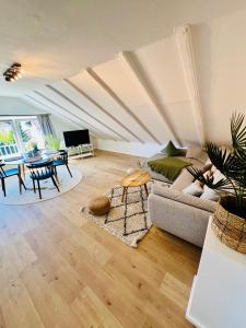 a living room with a couch and a table at Gemütliches Loft in Homburg - Komfort & Charme direkt an der Uniklinik mit Küche und Bad in Homburg +25 photos