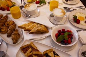 a table with plates of breakfast foods and cups of coffee at Hotel Piccolo Portofino in Portofino +37 photos